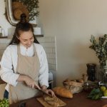 woman-wearing-apron-slicing-bread