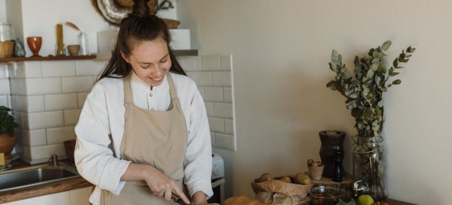 woman-wearing-apron-slicing-bread